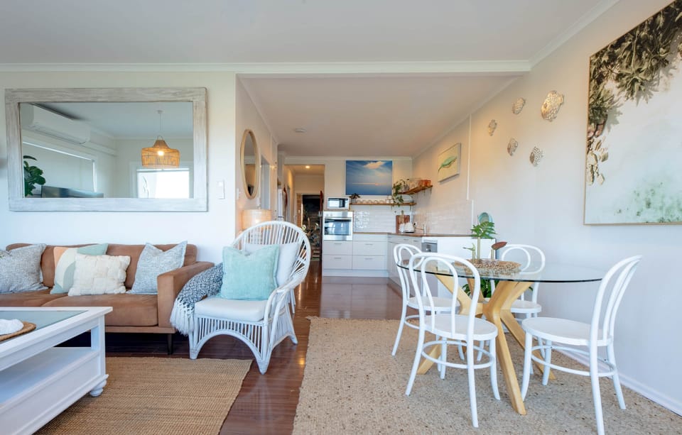 Light-filled dining with coastal styling and gorgeous bay views beyond.