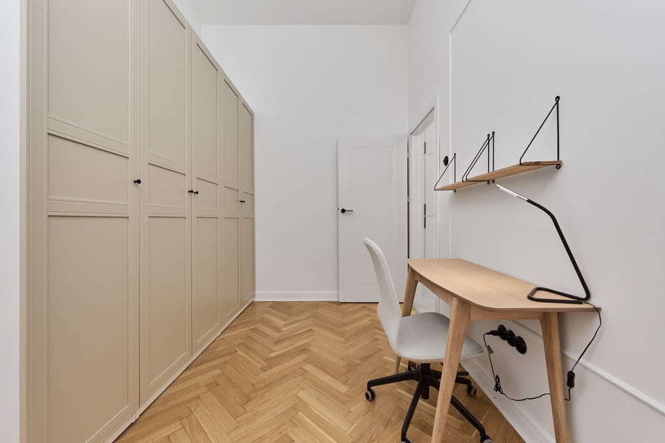 A bedroom with a double bed, built-in storage units, and simple yet elegant decor.