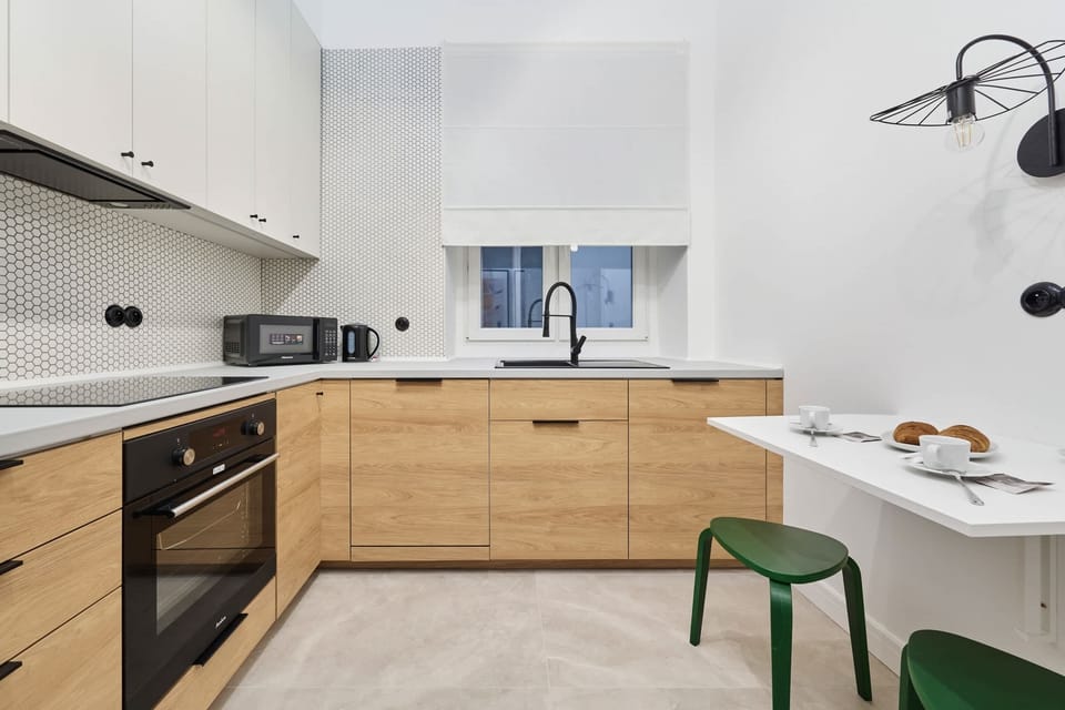 A closer look at a kitchen area featuring a microwave, kettle, and toaster neatly placed on the counter.