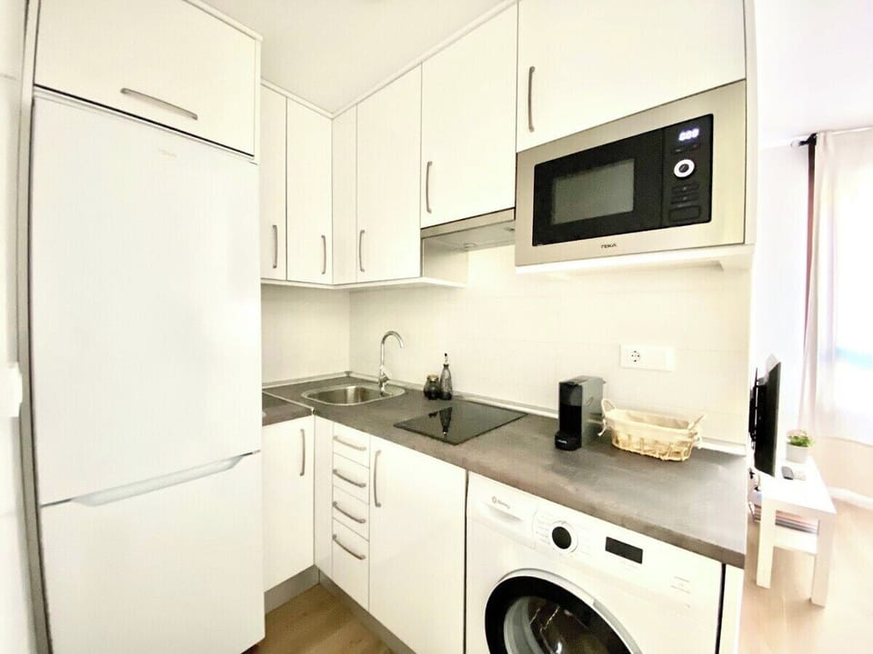 Cocina equipada con frigorífico, vitrocerámica, lavadora, microondas y fregadero / Kitchen equipped with fridge, ceramic stove, washing machine, microwave and sink