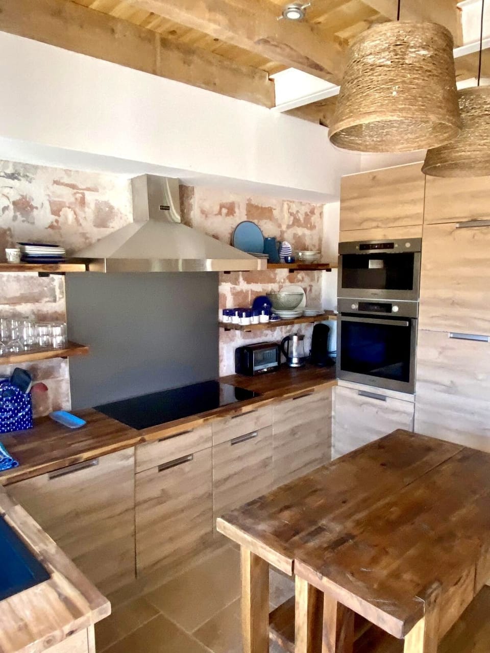 Kitchen with all new appliances and furniture, exposed brick walls, dishwasher 