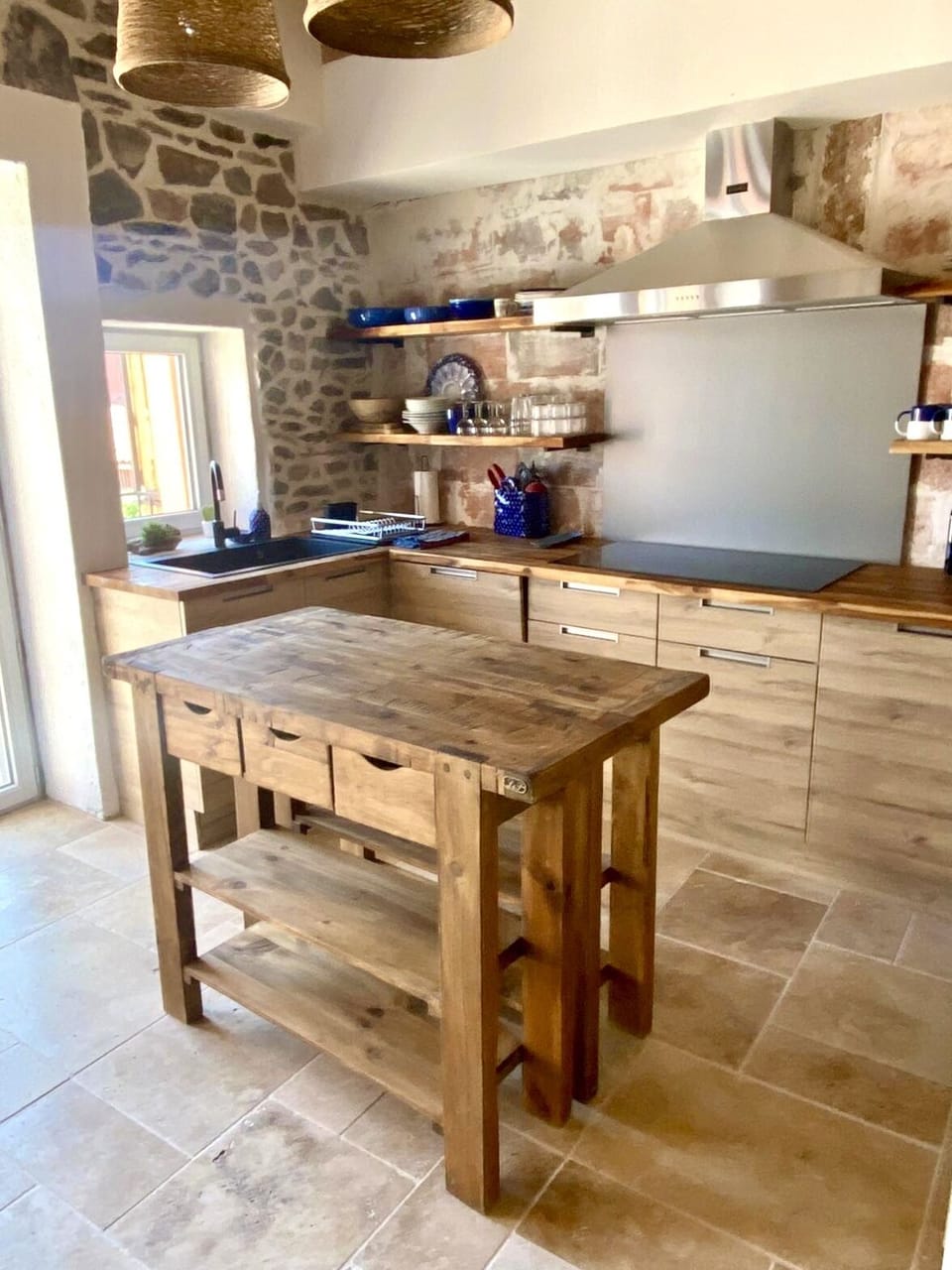 Kitchen with all new appliances and fixtures, exposed stone walls and brick wall