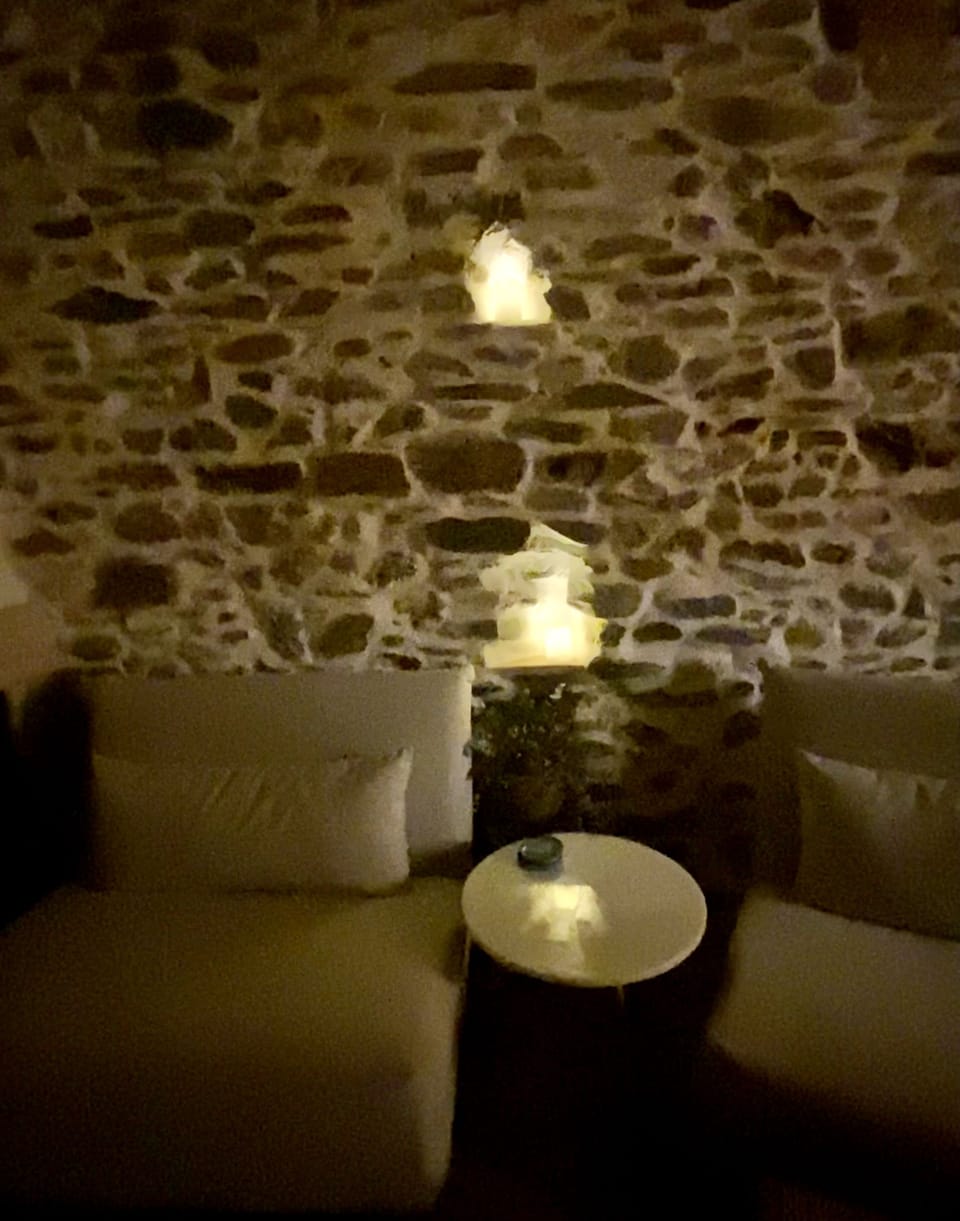Living room with candlelight and exposed stone walls
