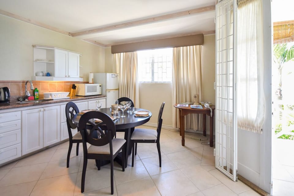 Open plan kitchen and eating area - window and patio open up to the sea