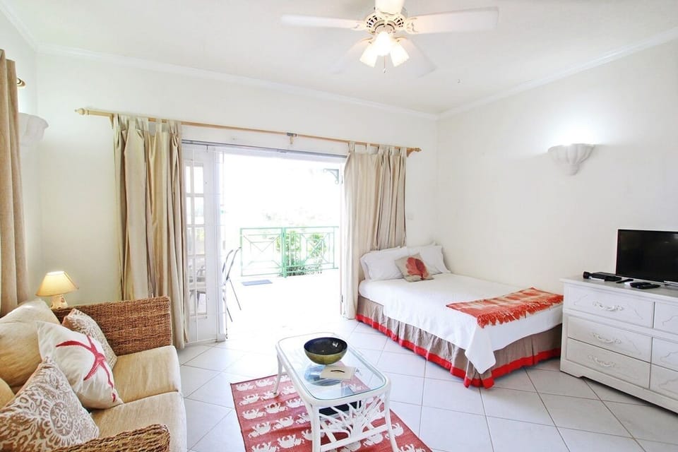 Double size bed and living area looking out to the patio