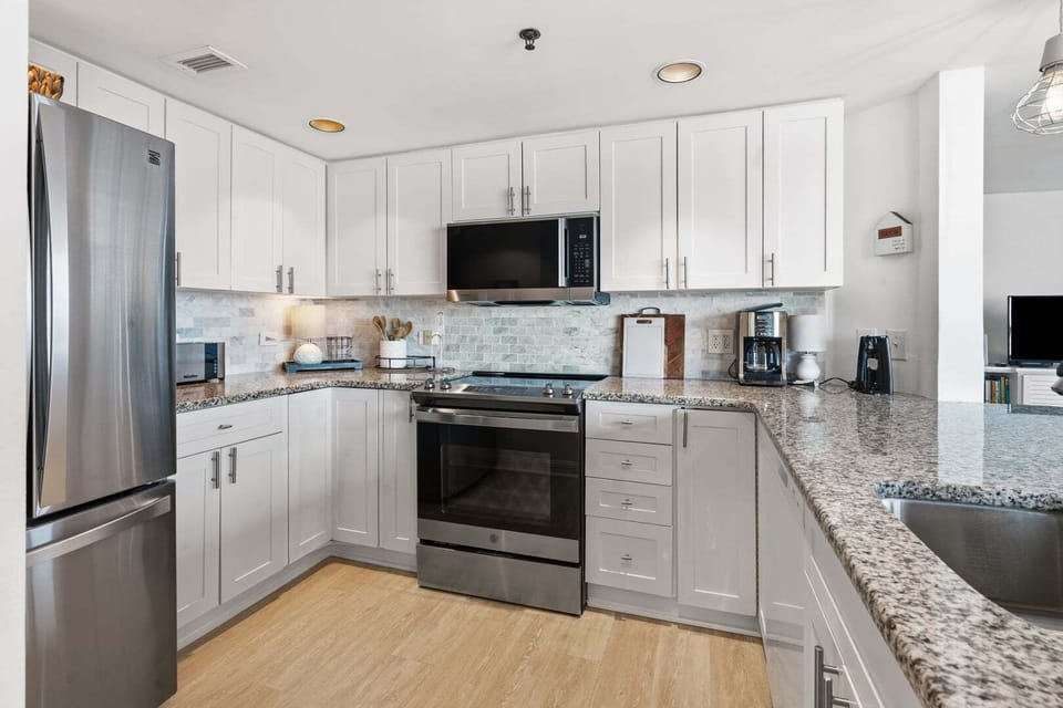 White cabinetry and full-size appliances in the kitchen at Seaside Resort 503, a 3-bedroom rental