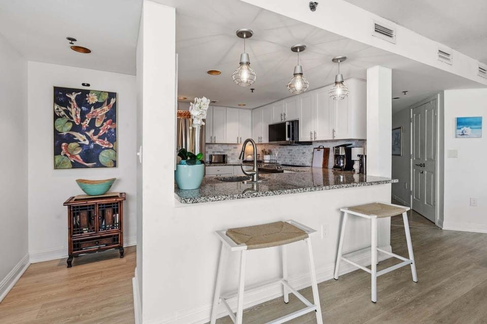Kitchen island with bar stools and white cabinetry at Seaside Resort 503 in Crescent Beach, North Myrtle Beach