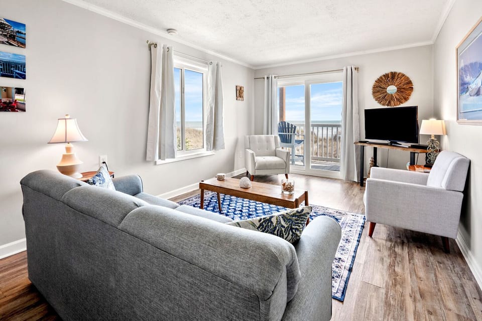 Living area with sectional seating and sliding doors to the ocean view at Windy Village A4 in Windy Hill