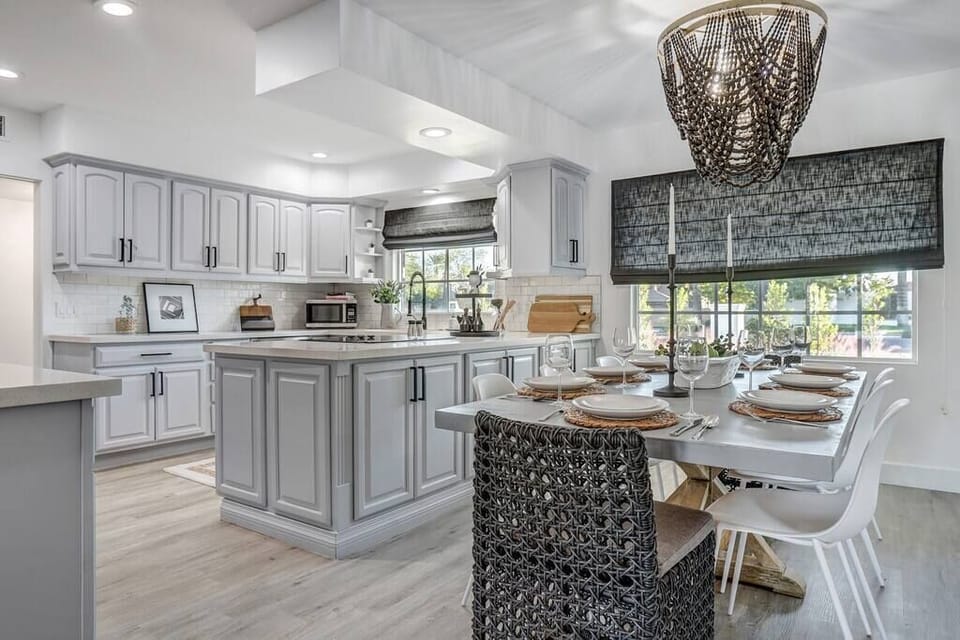 Modern kitchen and dining area with a large island and natural light from windows.