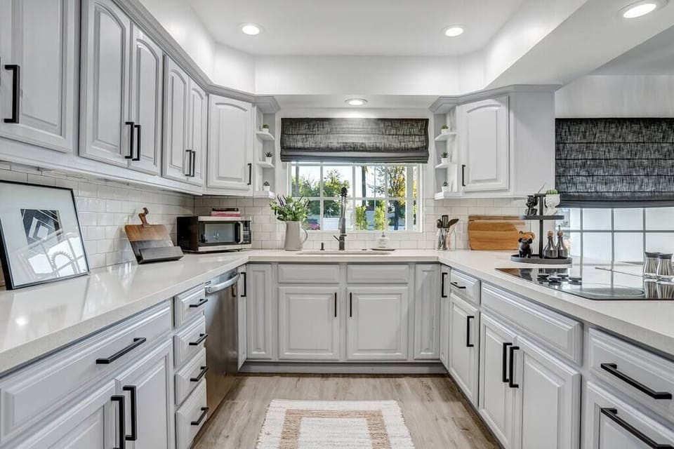 Bright kitchen with white cabinetry and modern appliances.