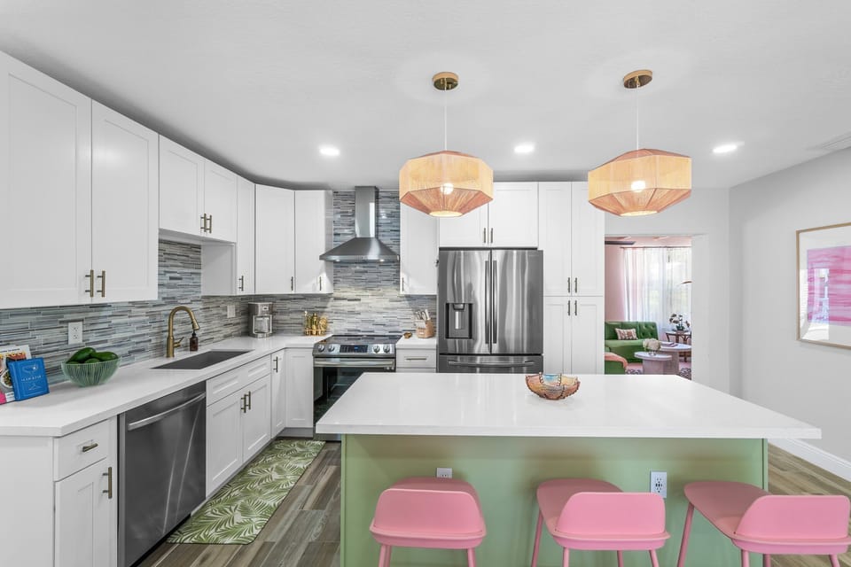 The brand-new chef’s kitchen is fully stocked with all of your cooking necessities and includes an island countertop, with 4 candy colored European bar stools.