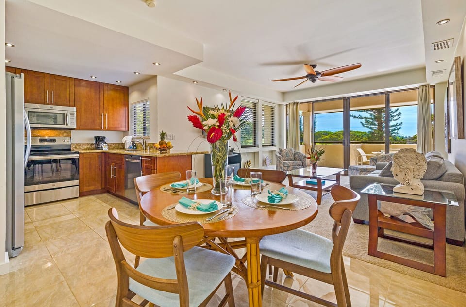Elegant dining space for four with tropical floral centerpiece and scenic views, just steps from Kapalua's hiking trails and golden beaches.
