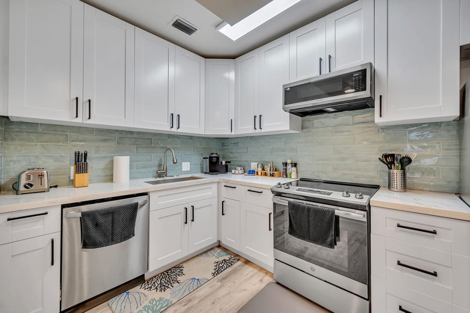 The kitchen is fully stocked with modern appliances and beautiful countertops & cupboards.