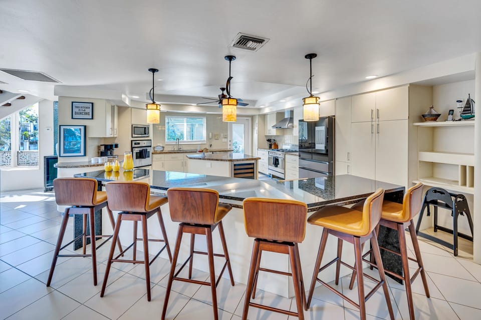 The large, eat in kitchen includes seating for eight, a professional gas stove and an oversized island.