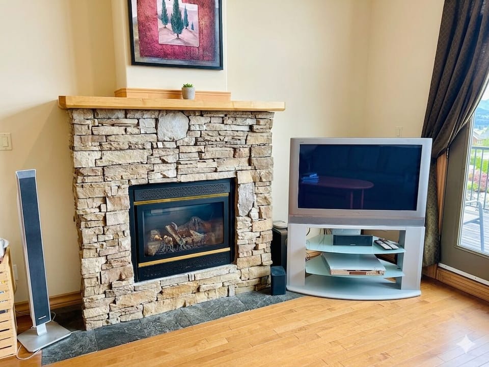 Natural gas fireplace and large TV in the main living room.