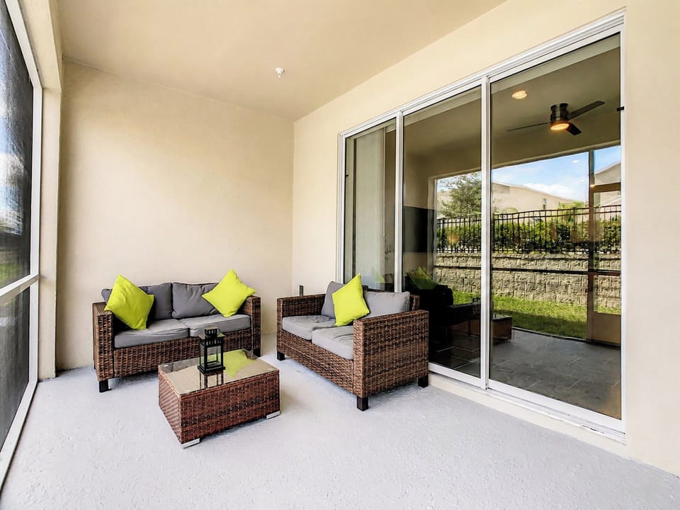Screened patio with cushioned wicker seating and coffee table
