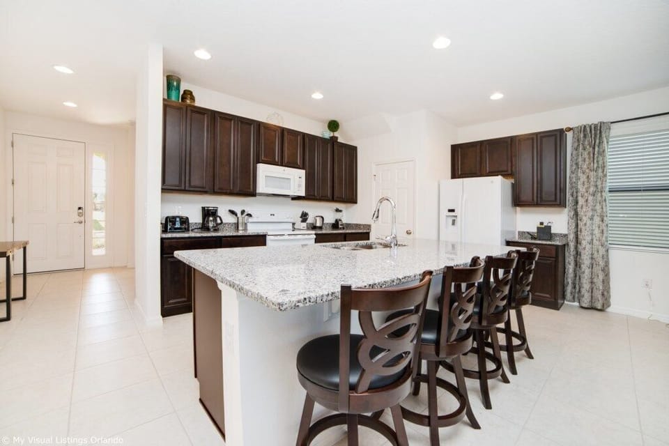 Modern kitchen with bar seating, stainless appliances, and sleek design.