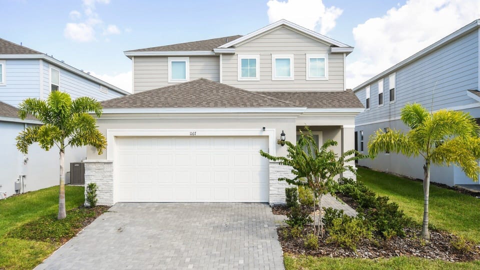 Stunning home, surrounded by lush greenery and featuring a convenient garage for a perfect blend of beauty and functionality