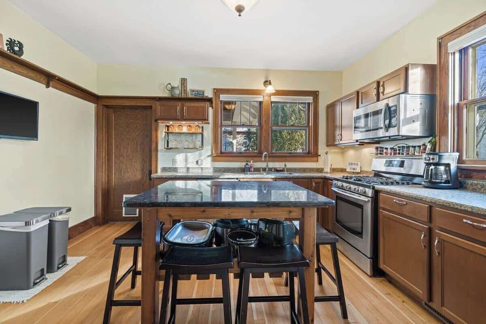 Along with the kitchen island there is additional seating and a TV.  
Included is a nice gas range stove, quiet Bosch dishwasher with sanitizing cycle, and French door refrigerator with many door and shelving options. 
The kitchen extends into the mudroom, which includes washer and dryer units.