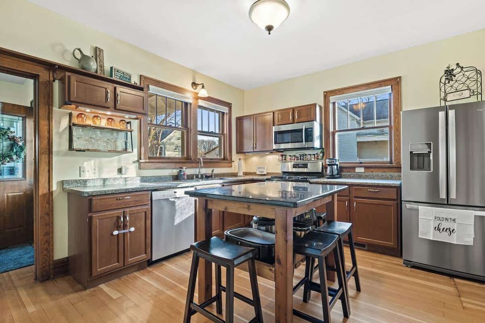 An updated kitchen with high quality stainless steel appliances and large granite island. The island offers additional space for cooking and eating.  There are many amenities provided in this well-lit space!