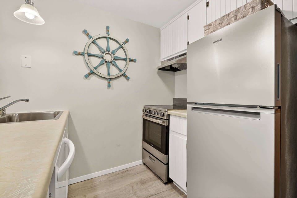 Step into your nautical-themed kitchen, perfectly equipped for preparing meals with modern appliances and charming coastal decor.
