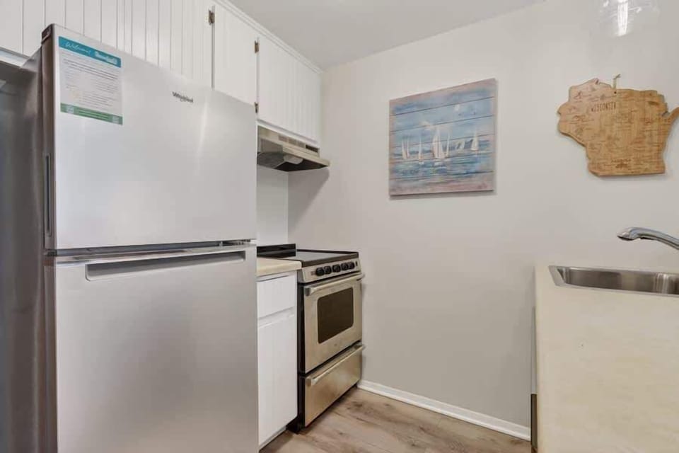 Your compact kitchen features stainless steel appliances and crisp white cabinetry, offering everything you need to prepare quick bites or full meals during your stay.