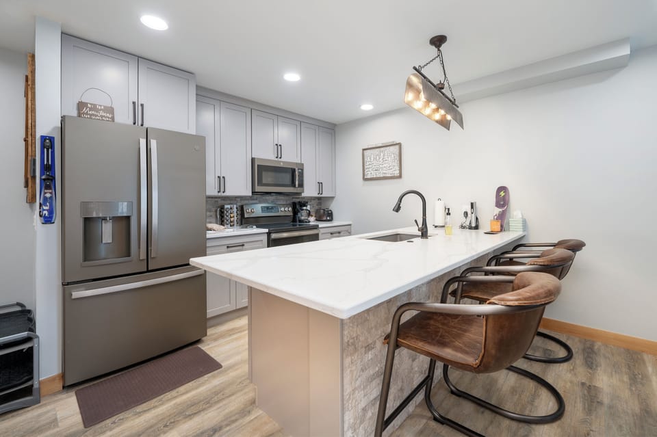 Cook memorable meals in your fully equipped kitchen featuring modern appliances, marble countertops, and a cozy breakfast bar.