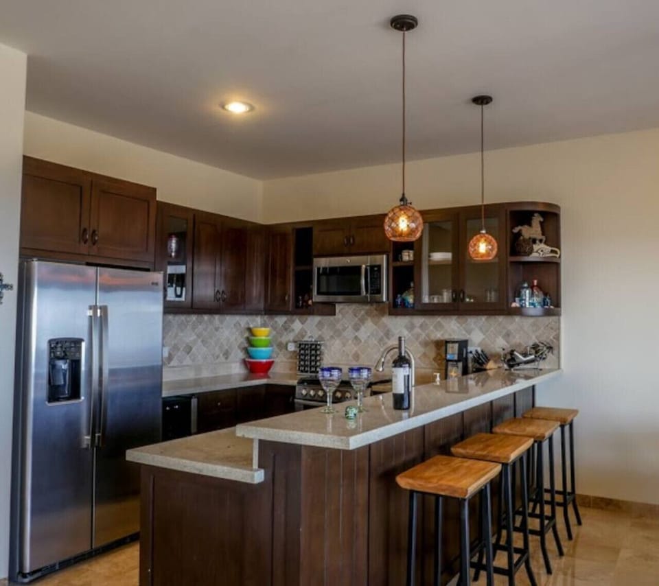 Fully equipped kitchen with stainless steel appliances and a breakfast bar.