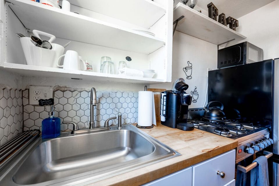 Kitchen: Sleek hexagon tiles and modern appliances make meal prep a delight in this vibrant space!