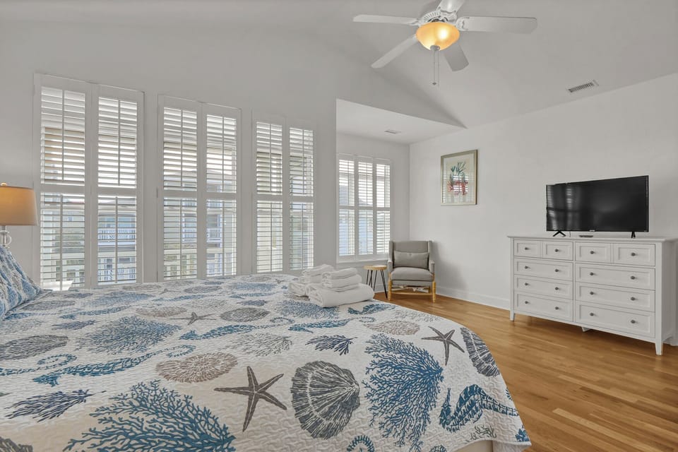 Drift off to sleep in your coastal-themed bedroom, where ocean breezes flow through shuttered windows and morning light creates the perfect seaside retreat.