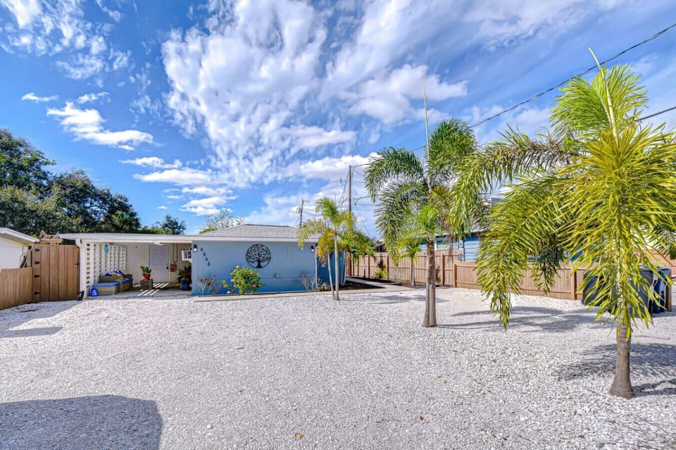 Enjoy plenty of driveway parking right in front of this bright and breezy coastal cottage — easy access for multiple vehicles, boats, or beach gear, all framed by swaying palms and sunshine.