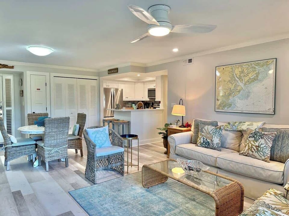 Open living and dining area with coastal-inspired decor and a modern kitchen.