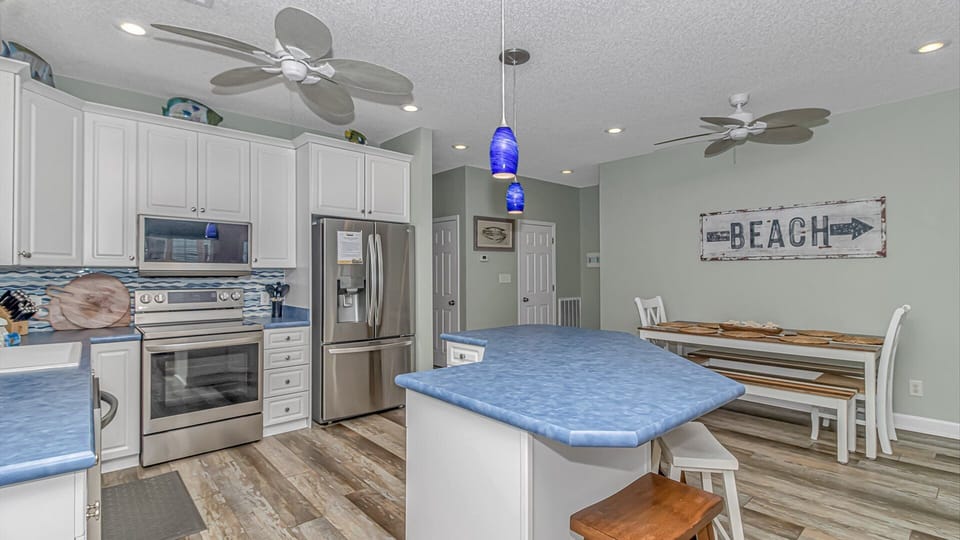 Cook your favorite meals in this bright, fully-equipped kitchen with stainless appliances and coastal charm.