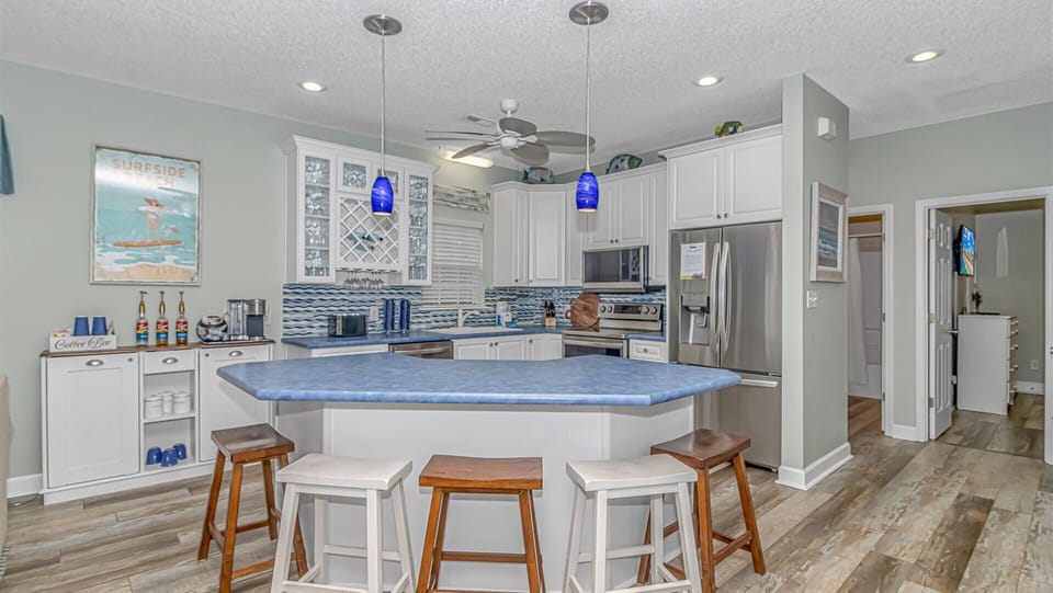 Your fully equipped gourmet kitchen invites culinary adventures with a spacious island, modern appliances, and coastal charm throughout.