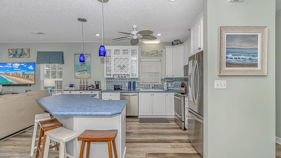 Your spacious kitchen features modern appliances, a large island for cooking together, and coastal touches that make every meal feel like a vacation.
