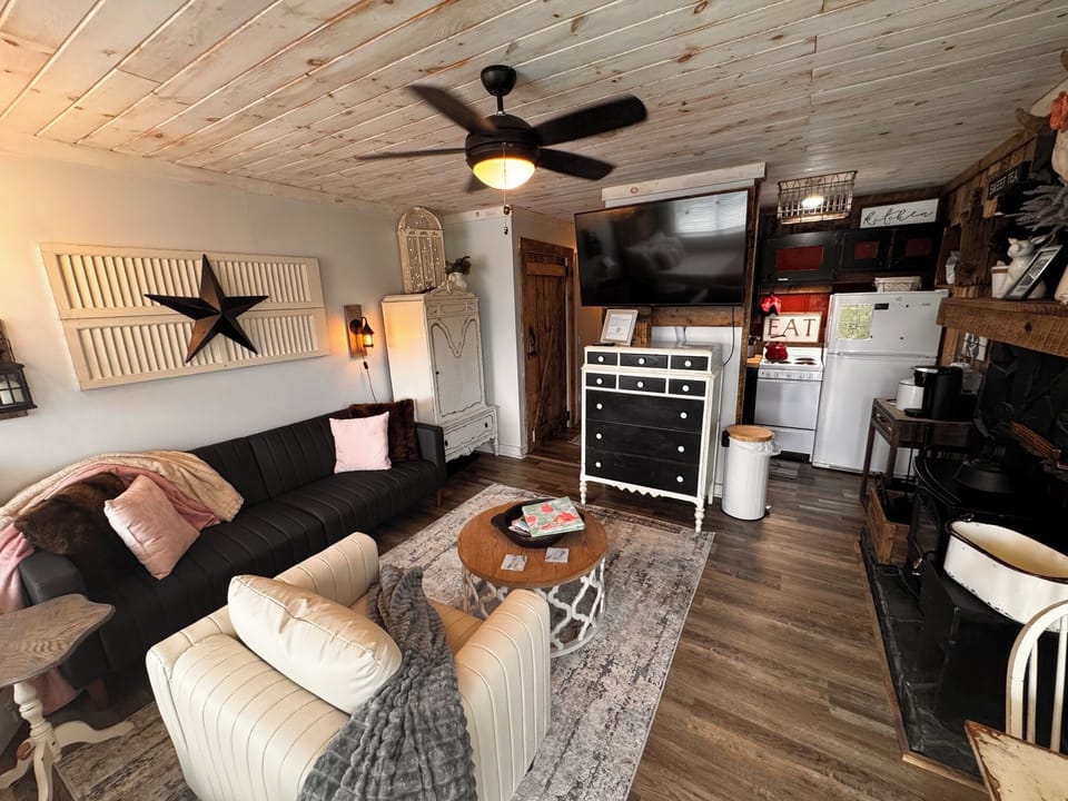 Cozy rustic lounge with wood ceilings, big TV, and charming cabin style