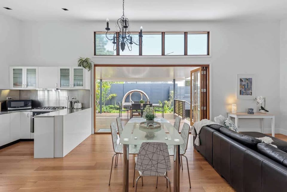 The rear, open plan kitchen, dining, lounge, bi-fold doors to covered private deck