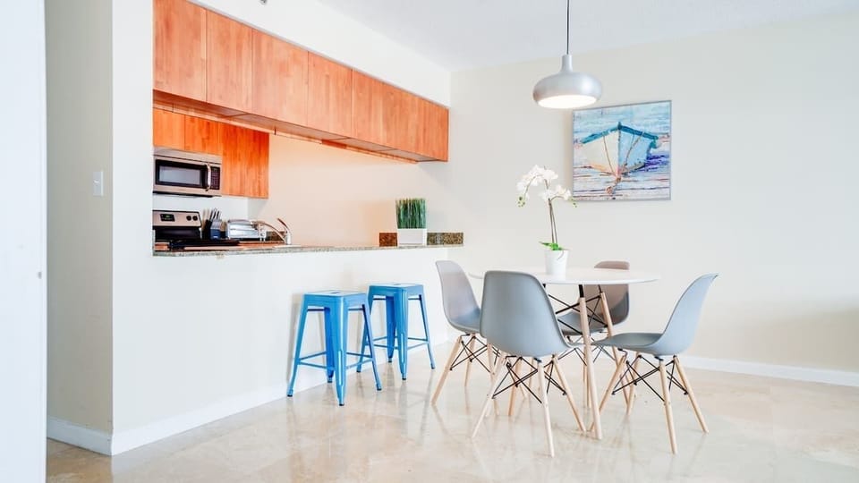 Kitchen with quality appliances, cookware, and cozy 4-seater dining table