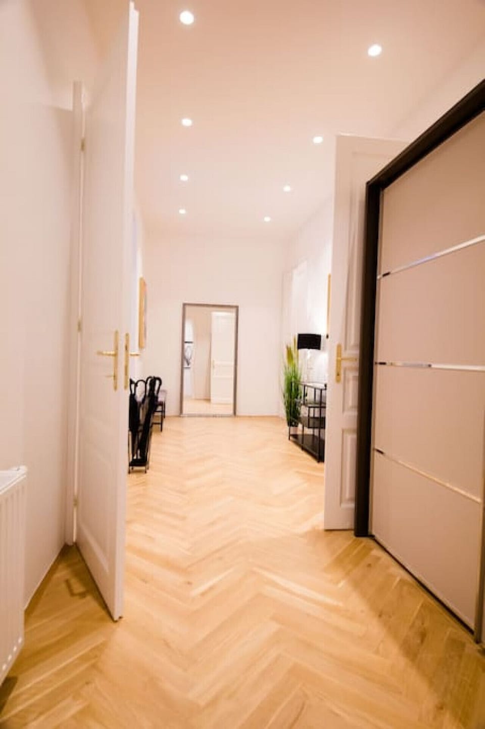 Weiterer Blickwinkel auf den geräumigen Flur der Altbauwohnung.