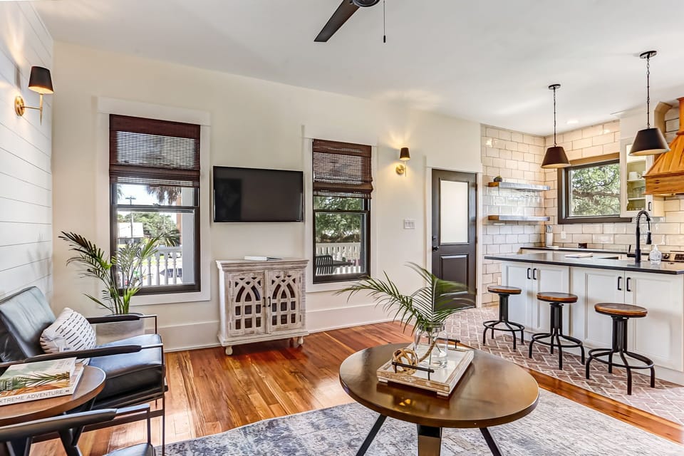 - Airy layout flows from a barstool lined kitchen island into a bright living room with cozy vibes  
- Cook, sip, or catch up under pendant lights and white tile backsplashes with wood accents  
- Open concept comfort makes it easy to stay in and feel at home