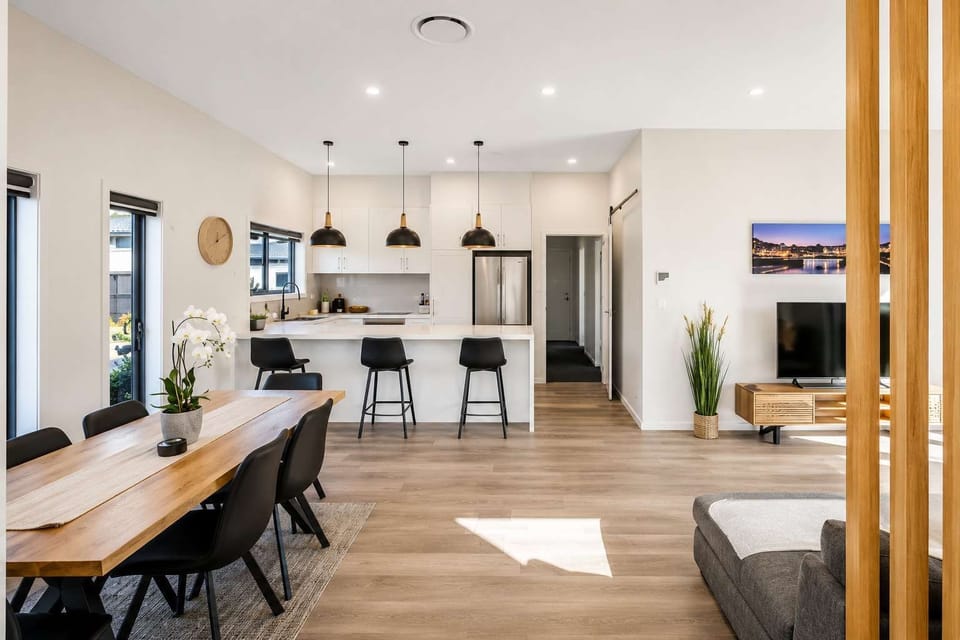 Modern, fully equipped kitchen with generous bench space and breakfast-bar seating.