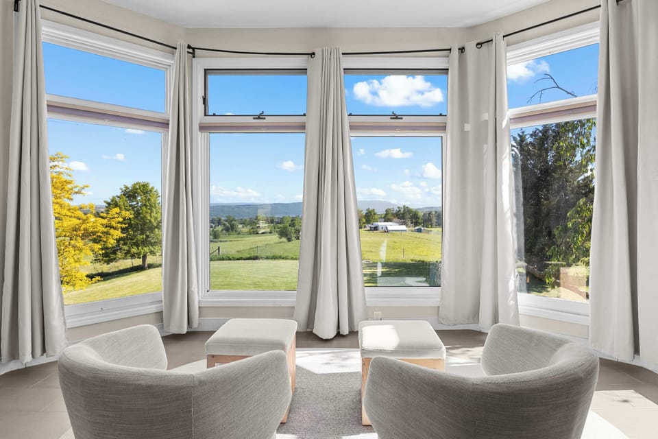 Wake up to bright natural light and serene views in the primary bedroom.