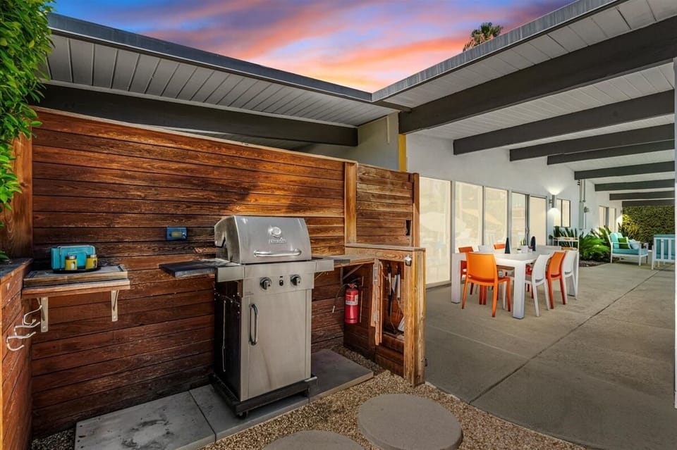 Outdoor BBQ grill, prep station, and poolside dining area.