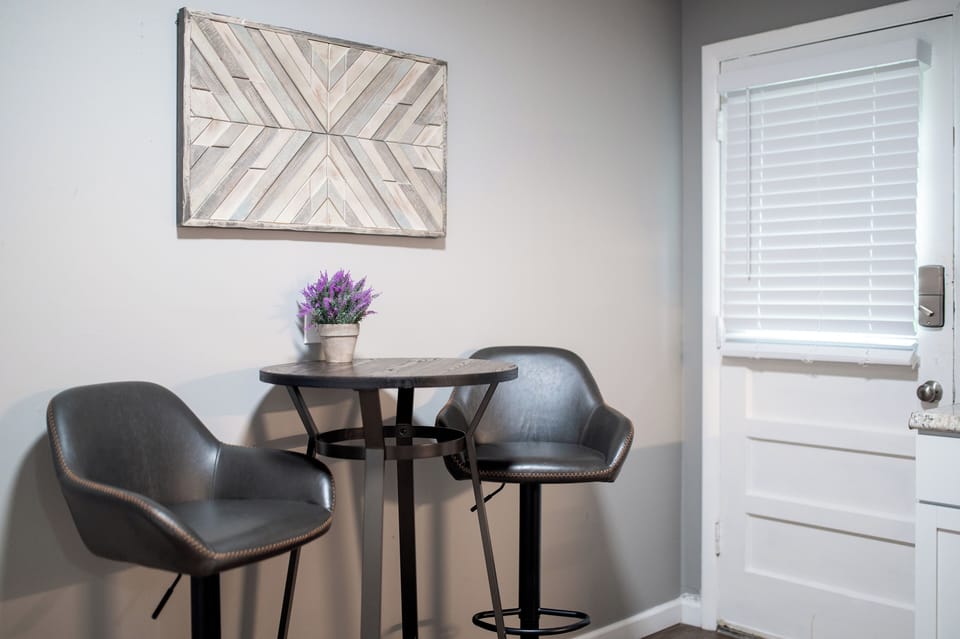 A compact dining nook provides a round high-top table and two chairs beside the back door.