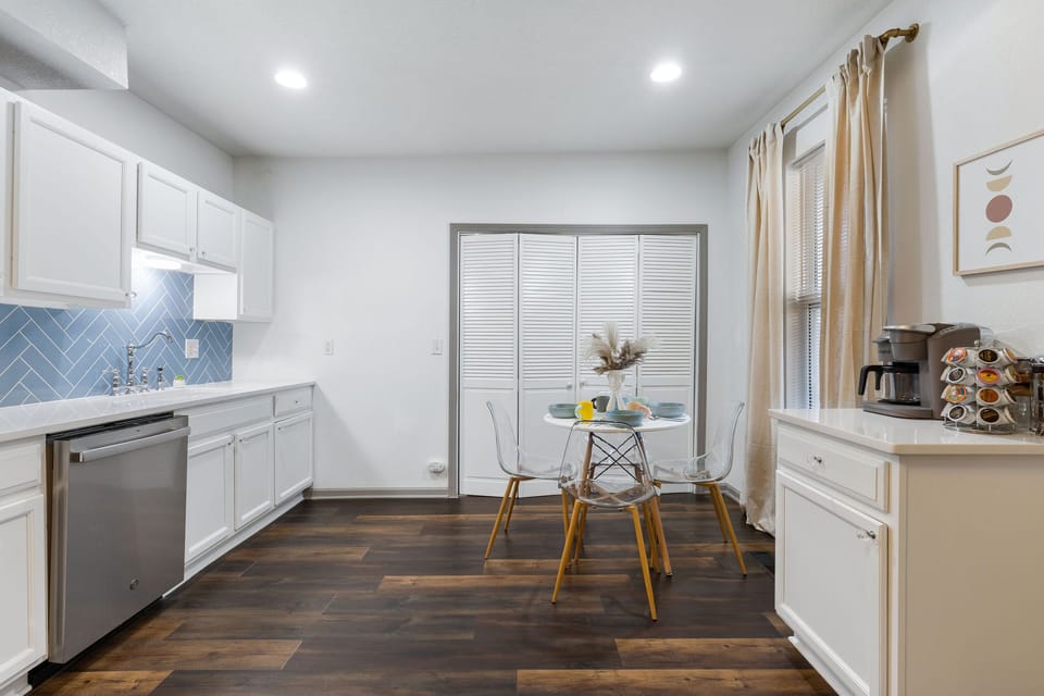 Bright, spacious kitchen with ample counter space, full-size fridge, and stylish blue tile backsplash—ideal for extended stays and home-cooked meals.