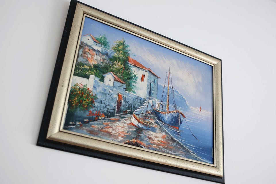 A framed wall painting of a sailboat, adding a nautical touch to the decor.





