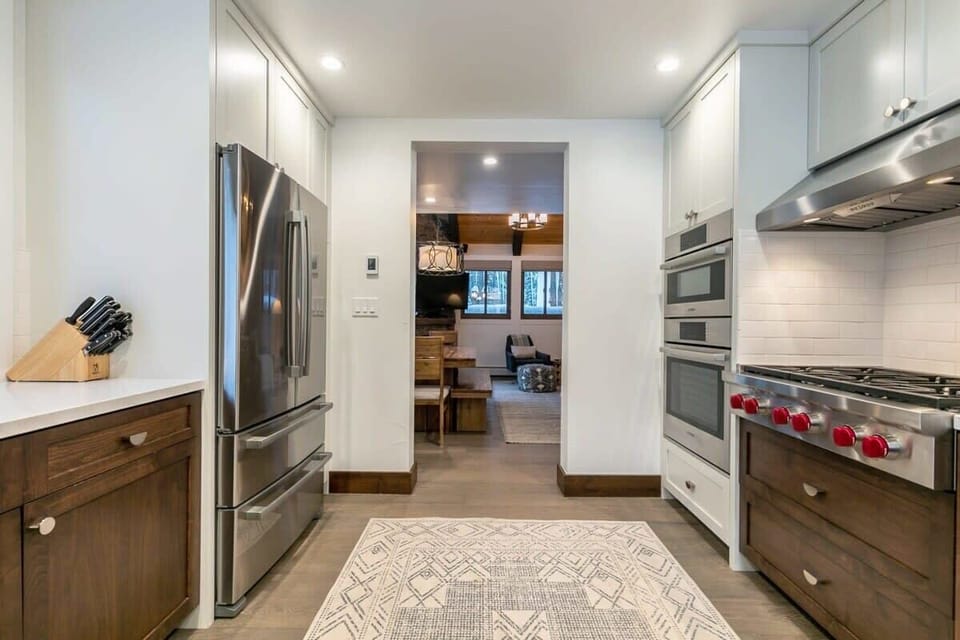 The fully equipped kitchen features top-of-the-line stainless steel appliances such as the 36” Wolf stovetop range, beautiful cabinets and countertops, and a walk-in pantry.