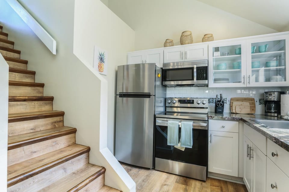 Enjoy the convenience of a modern kitchen setup, including fridge, oven, and microwave, all in a compact layout.