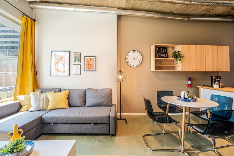 Bright and open living room with vibrant modern decor, featuring a sofa bed for an extra guest or couple