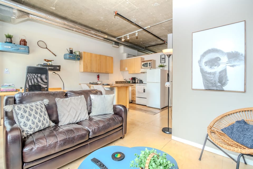 Cozy living room with a simulated brick accent wall and large windows showcasing stunning 8th-floor city views